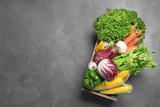 Fototapeta Kuchnia - Crate with fresh vegetables on grey table, top view. Space for text