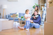© Krakenimages.com - Beautiful family sitting on the floor playing with his kid at new home around cardboard boxes