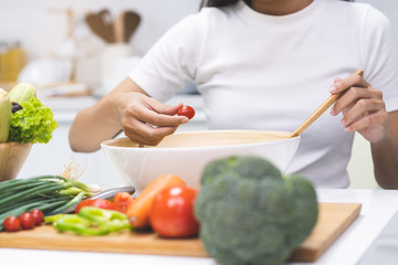 Wall Mural - Eat healthy food for good wellness health concept. Woman cooking salad menu with fresh organic vegetables