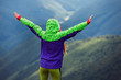© Андрей Репетий - Traveling girl with a raised hands standing on the top of mountain while feeling freedom