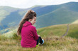 © Андрей Репетий - Young girl straightening hair in the mountains with a beautiful landscape. Rear view.