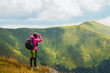 © Андрей Репетий - Girl hiker with a backpack standing on the edge of mountain looking into the distance at the beauty of nature