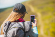 © Андрей Репетий - Young woman hiker taking photo with smartphone while climbing up the mountain