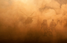 2 Soldiers Helping Wounded Soldier Between Dust In Battle Field To Board The Helicopter