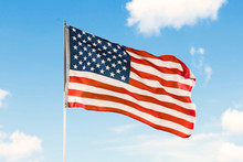 American Flag Waving Under Blue Sky