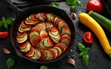 Ratatouille Vegetable Stew With Zucchini, Eggplants, Tomatoes, Garlic, Onion And Basil. On Cast Iron Pan. Traditional French Food.