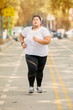 © Creativa Images - Overweight woman runs on the road at autumn