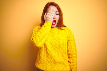 Canvas Print - Beautiful redhead woman wearing winter sweater standing over isolated yellow background Yawning tired covering half face, eye and mouth with hand. Face hurts in pain.