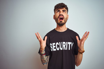 Sticker - Young safeguard man with tattoo wering security uniform over isolated white background crazy and mad shouting and yelling with aggressive expression and arms raised. Frustration concept.