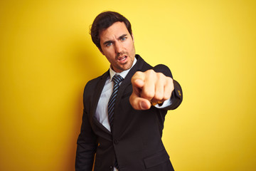 Sticker - Young handsome businessman wearing suit and tie standing over isolated yellow background pointing displeased and frustrated to the camera, angry and furious with you