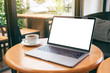 © Farknot Architect - Mockup image of laptop computer with blank white desktop screen with coffee cup on wooden table