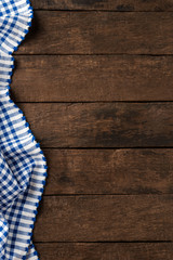 Wall Mural - Blue checkered tablecloth on wooden background with copyspace