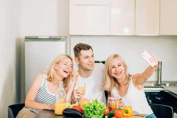 Wall Mural - Friends sitting at table in kitchen