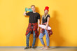 © Pixel-Shot - Couple in stylish t-shirts and with skateboards near color wall