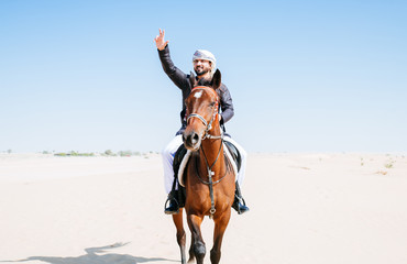 Wall Mural - Arabian man with traditional clothes riding his horse