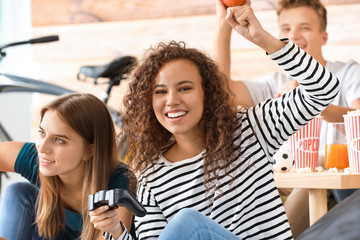 Wall Mural - Teenagers playing video game at home