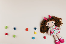 A Doll And Colourful Objects On A White Background