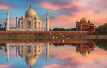 Fototapete - Taj Mahal Agra at sunset with water reflection and moody sky. Taj Mahal is a UNESCO World Heritage site on the banks of river Yamuna at Uttar Pradesh India.