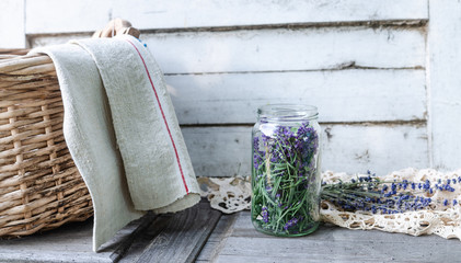 Wall Mural - A glass jar full of freshly harvested lavender blossoms in vintage traditional environment with homemade corf and towel