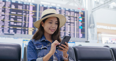 Poster - Woman use of mobile phone in the airport