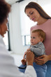 © lordn - Mother and her baby, visiting the doctor for a medical examination. Pediatrician doing an infant medical exam listening with a stethoscope.