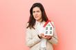 © Asier - Young caucasian woman holding a house icon