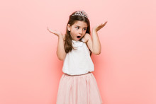 Little Girl Wearing A Princess Look Surprised And Shocked.