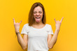 © Asier - Young natural caucasian woman showing rock gesture with fingers