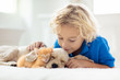 © famveldman - Child, dog and cat. Kids play with puppy, kitten.