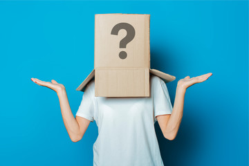 Young woman with a cardboard box on her head on a blue backgroun