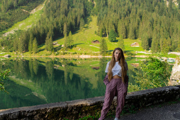 Wall Mural - Beautiful young sports girl on a background of a forest in the mountains