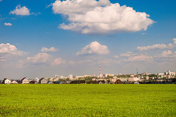 Wall Mural - Green field slope and city skyline in the background. Belgorod city, Southwest 2.1 district, Russia.