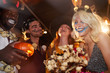 © Seventyfour - Low angle view at group of friends enjoying Halloween party in nightclub, focus on smiling young woman having fun