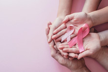 Hands Holding Pink Ribbons On Pink Background, Breast Cancer Awareness And October Pink Day, World Cancer Day