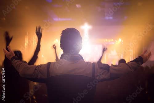 Worship concept: Christians raising  hands in praise and worship night