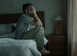 © TheVisualsYouNeed - Attractive depressed and sad man at home sitting on bed crying desperate suffering depression problem