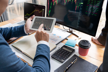 Team of stockbrokers Discussing with display screens Analyzing data, graphs and reports of stock market trading for investment