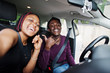 © AS Photo Family - Beautiful young african american couple sitting on the front passenger seats while handsome man driving a car. Making selfie together.