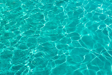  Water ripples on blue tiled swimming pool background. View from above