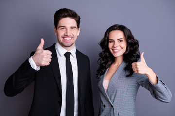 Wall Mural - Portrait of beautiful businesspeople with brunette hairstyle wavy curly hair showing thumb up approving sales wearing black blazer jacket tuxedo isolated over grey background