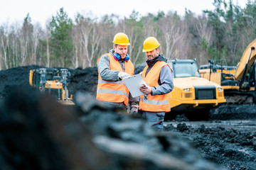 Wall Mural - Workers in quarry looking at a plan