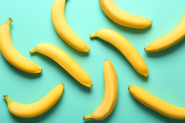 Many sweet ripe bananas on color background