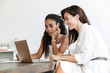 © Drobot Dean - Women colleagues at workplace indoors in office work with paper documents and laptop computer.