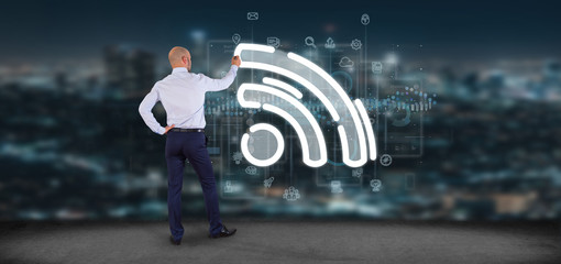 Poster - Businessman holding a wifi icon with data all around