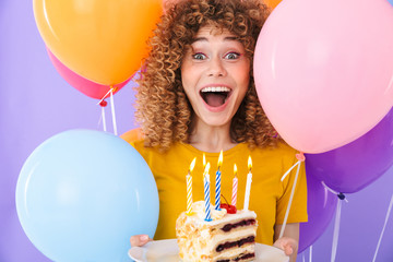 Canvas Print - Image of excited young woman celebrating birthday with multicolored air balloons and piece of cake