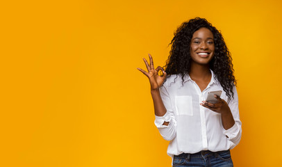 Cute black lady showing her satisfaction with new cellphone