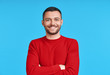 © GVS - Happy smiling handsome man with crossed arms looking to camera over blue background