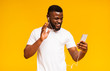 Cheerful black man making video call with smartphone