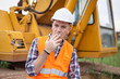 © Pituk - Portrait of handsome guy engineers sit and relax by smoking on a crane during breaks in the construction site, and looking at the camera