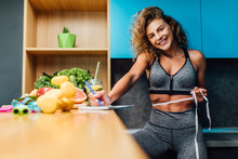Woman Fitness Dietolog.  Beautiful Girl In Sportswear Measuring, Healthy Green Food. Write Recipe.